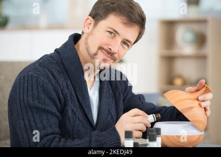 homme utilisant un diffuseur d'huile d'arome à la maison Banque D'Images