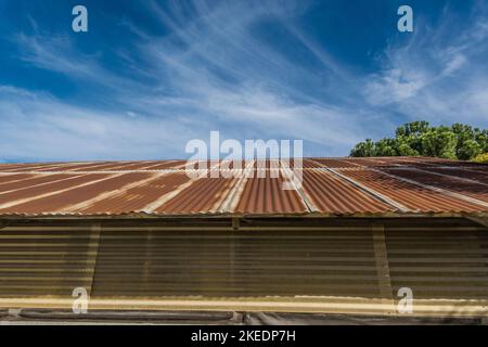 Un toit en métal rouillé avec un ciel spectaculaire, bleu profond avec des nuages murmures dans le mérou, dans le petit village de Los Olivos, Californie. Banque D'Images