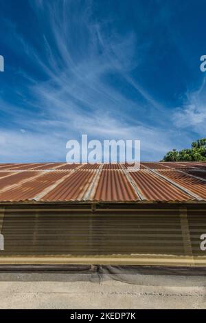 Un toit en métal rouillé avec un ciel spectaculaire, bleu profond avec des nuages murmures dans le mérou, dans le petit village de Los Olivos, Californie. Banque D'Images