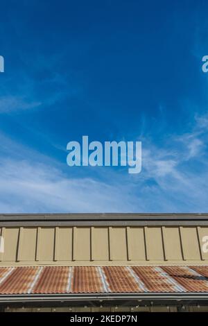 Un toit en métal rouillé avec un ciel spectaculaire, bleu profond avec des nuages murmures dans le mérou, dans le petit village de Los Olivos, Californie. Banque D'Images