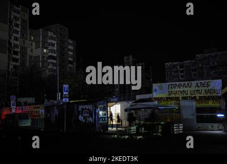 Kiev, Ukraine. 11th novembre 2022. Une lumière est visible sur un magasin de rue dans une rue sombre de Kiev. L'armée russe a mené des attaques massives de roquettes et de drones kamikaze sur les infrastructures énergétiques ukrainiennes. Selon les estimations des experts, 40 % des infrastructures énergétiques sont aujourd’hui détruites ou endommagées. Après de graves dommages au réseau électrique dans de nombreuses villes d'Ukraine, la compagnie nationale d'électricité Ukrenergo a introduit des coupures d'électricité d'urgence et toutes les heures. Crédit : SOPA Images Limited/Alamy Live News Banque D'Images