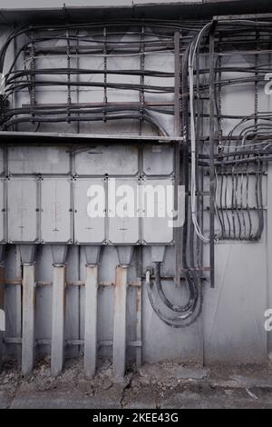 Un cliché vertical des fils et des câbles électriques sur le mur à l'extérieur Banque D'Images