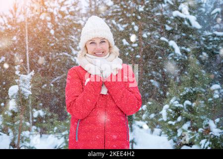 Femme en vêtements chauds pose pour la photo dans la forêt d'hiver Banque D'Images