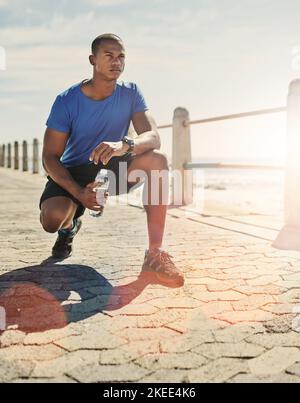 Maintien de sa forme parfaite. Un jeune homme sportif qui se croque dehors. Banque D'Images