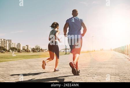 Continuez à pousser. Un jeune couple sportif pour courir ensemble. Banque D'Images