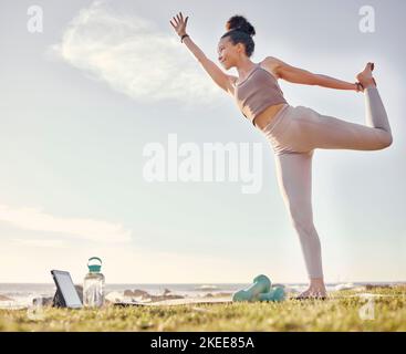 Yoga, tablette et nature avec une femme athlète au bord de l'océan pour la paix intérieure, le bien-être ou l'exercice zen. Fitness, santé et technologie avec un yogi femelle Banque D'Images