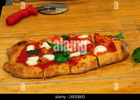 Pizza ou focaccia italienne cuite dans un four à bois avec tomates, fromage de buffle et basilic Banque D'Images