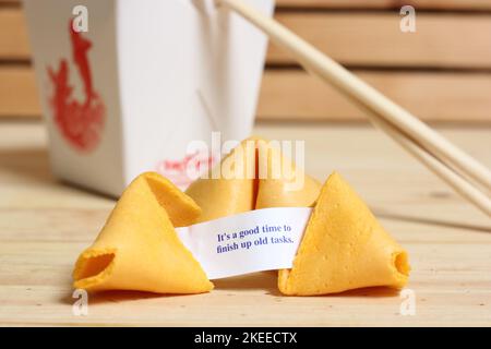 Fortune cookie avec phrase c'est le bon moment pour terminer de vieilles tâches. Retirer le récipient à l'arrière Banque D'Images