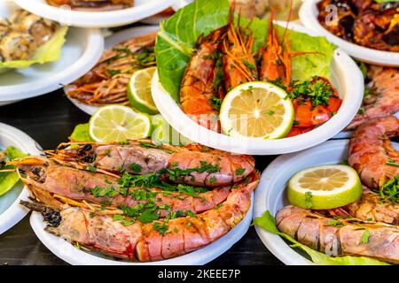 Assiettes de grosses crevettes cuites à vendre au marché de Capo (Mercado del Capo), Palerme, Sicile, Italie. Banque D'Images