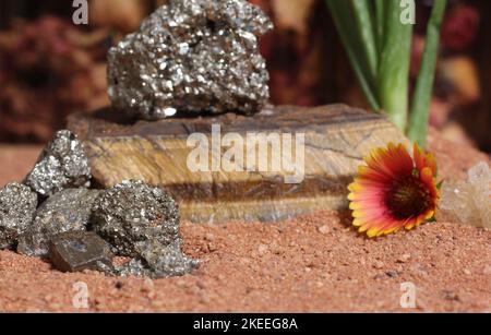 Fleur avec des rochers de pyrite et des cristaux de Chakra sur le sable rouge australien Banque D'Images