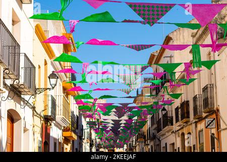 Un certain nombre de drapeaux triangulaires colorés accrochés entre les bâtiments résidentiels par temps ensoleillé Banque D'Images