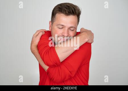Homme caucasien souriant plein d'assurance tenant s'embrasser Banque D'Images