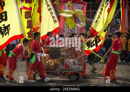 Les membres de l'équipe de danse du dragon tirent une voiturette avec un tambour, un gong et des ponnants cérémoniels au site du festival décennal Da JIU, Kam Tin, Hong Kong, 2015 Banque D'Images