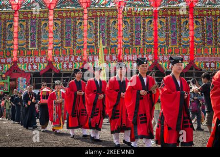 Des prêtres taoïstes rouges dirigent les anciens du village dans une procession rituelle à travers le site décennal du festival Da Jiu, Kam Tin, Hong Kong, 2015 Banque D'Images