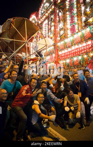 Les villageois posent pour des photos avec l'effigie du Roi fantôme dans la rue à Kam Tin la nuit pendant le festival décennal Da JIU, Hong Kong, 2015 Banque D'Images