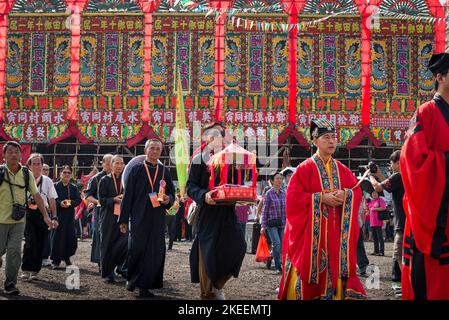Des prêtres taoïstes rouges dirigent les anciens du village dans une procession rituelle à travers le site décennal du festival Da Jiu, Kam Tin, Hong Kong, 2015 Banque D'Images