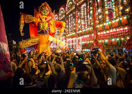 Les villageois posent pour des photos avec l'effigie du Roi fantôme dans la rue à Kam Tin la nuit pendant le festival décennal Da JIU, Hong Kong, 2015 Banque D'Images