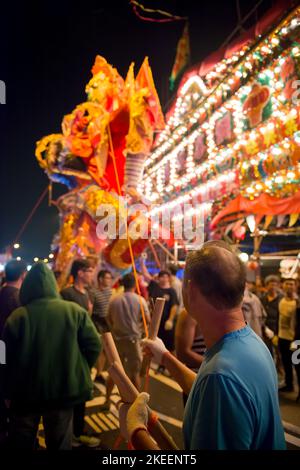 Un villageois soutient l'énorme effigie du Roi fantôme dans la rue de Kam Tin la nuit pendant le festival décennal Da JIU, Hong Kong, 2015 Banque D'Images