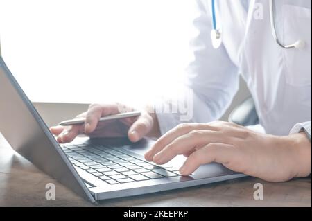 Concept de technologie médicale. Médecin travaille avec un ordinateur portable. Médecin utilisant un ordinateur portable pour les appels vidéo en ligne, parler à distance au patient, prescrire des médicaments. Téléobjectif Banque D'Images