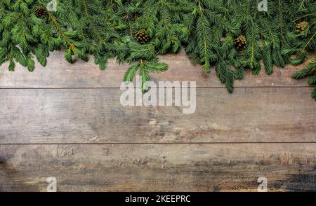 arrière-plan rustique de noël. Modèle de message d'accueil Noël hiver. Branches d'arbre de Noël, et cônes sur fond en bois foncé avec espace de copie Banque D'Images