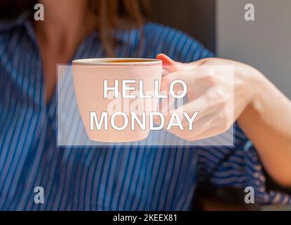 Concept Hello monday. Mots sur la tasse de café dans la main des femmes. Banque D'Images