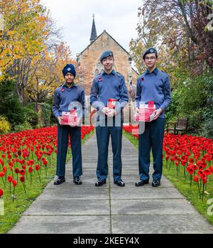 Musselburgh, East Lothian, Écosse, Royaume-Uni, 12th novembre 2022. Exposition de coquelicots à la haute église St Andrew : des centaines de coquelicots crochetés sont exposés dans le jardin devant l'église pour le jour du souvenir. Photo : les cadets de l'air Kishan, Guy et Ethan contribuent à l'attrait du coquelicot écossais. Crédit : Sally Anderson/Alay Live News Banque D'Images