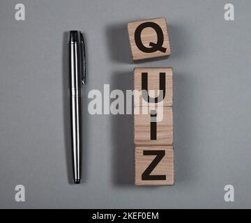 Concept Quizz ou quizz. Mot sur cubes de bois sur fond gris. Banque D'Images