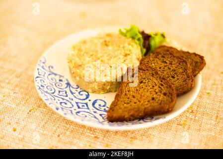 Collation nationale juive. Hareng haché sur une assiette ethnique et tranches de pain de seigle noir. Restaurant. Café. Banque D'Images