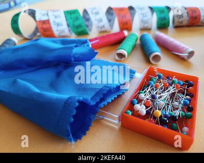 Accessoires pour la couture et la couture de fils et de tissus sur fond en bois. Banque D'Images