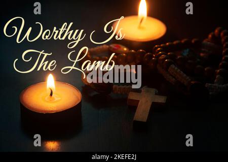 Digne est le texte de l'Agneau avec le Saint Rosaire et les bougies de combustion de fond. Concept de prière chrétienne et de religion. Banque D'Images