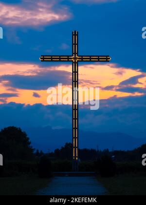 Brezje, Slovénie - 28 juillet 2022 : vue d'une heure bleue sur une grande croix extérieure illuminée Banque D'Images