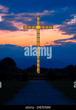 Brezje, Slovénie - 28 juillet 2022 : vue d'une heure bleue sur une grande croix extérieure illuminée Banque D'Images