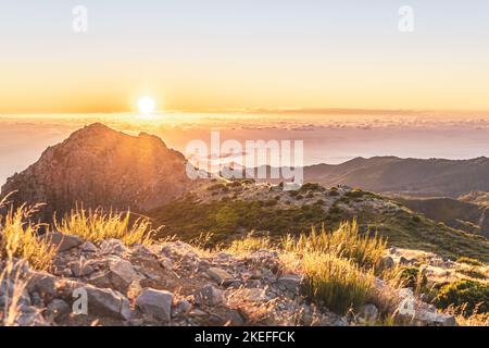 Description: Touristes regardant le lever du soleil sur le magnifique paysage de montagne de Pico do Ariero. Pico do Arieiro, île de Madère, Portugal, Europe. Banque D'Images