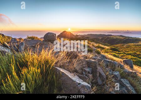 Description: Touristes regardant le lever du soleil sur le magnifique paysage de montagne de Pico do Ariero. Pico do Arieiro, île de Madère, Portugal, Europe. Banque D'Images