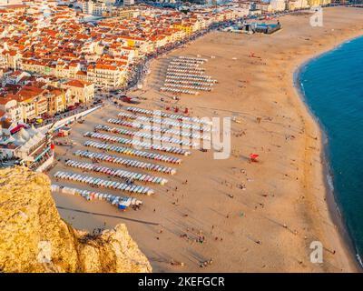 Vue panoramique sur la plage de Nazaré (praia de Nazaré) avec cabines de baignade colorées et paysage urbain du village à backgroung, Portugal Banque D'Images