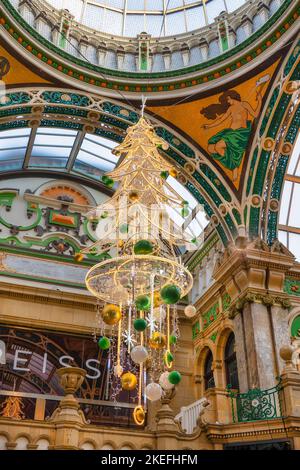 Arbre de Noël artificiel décoré de grandes boules suspendues à un toit à la galerie marchande du quartier Victoria à Leeds, West Yorkshire, Angleterre, Royaume-Uni. Banque D'Images