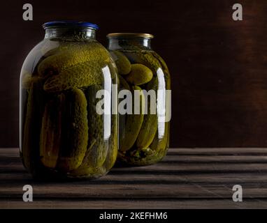 Concombres marinés en conserve dans des pots sur fond de table en bois. Plats faits maison. Gros plan Banque D'Images