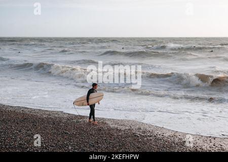 Seven Sisters, Royaume-Uni - 1 octobre 2022: Surfez avec une planche à pied sur la plage par les falaises de craie de sept Sœurs, l'une des plus longues étendues de déferstation Banque D'Images