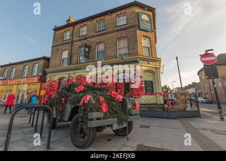 Southend on Sea, Royaume-Uni. 12 novembre 2022. Extérieur du pub Park Tavern décoré de grands coquelicots rouges sur filet vert en commémoration du jour du souvenir. Le bâtiment en briques de deux étages présente des fenêtres cintrées et une architecture traditionnelle. Des panneaux de tableau noir sont placés sur le trottoir, contribuant ainsi à l'affichage axé sur la communauté. Penelope Barritt/Alamy Live News Banque D'Images