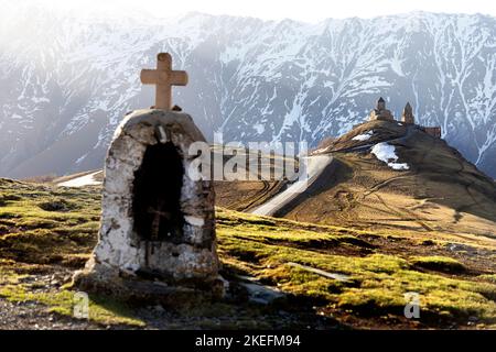 Petite chapelle et église de la Trinité de Gergeti à l'arrière au printemps lumière du matin avec montagne enneigée à l'arrière, Kazbegi, Géorgie, Europe Banque D'Images