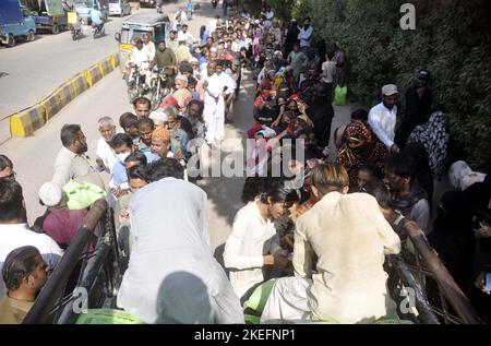 Les gens se rassemblent pour acheter des sacs de farine sur le prix des subventions d'un magasin d'utilité mobile vendu par le gouvernement de Sindh, comme le prix des articles généraux utilisés quotidiennement ont touché le ciel en raison de la hausse des prix dans le pays, près de radio Pakistan à Hyderabad samedi, 12 novembre 2022. Banque D'Images