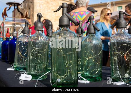 Gros plan de vieilles bouteilles en verre siphon, utilisées comme lampes décoratives, exposées dans un marché de rue Banque D'Images