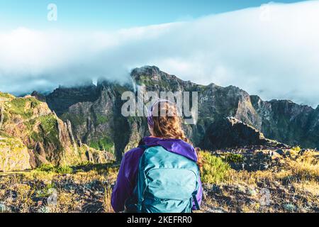 Description: Randonneur regardant le beau paysage de montagne de Pico Ruivo dans la matinée. Pico do Arieiro, île de Madère, Portugal, Europe. Banque D'Images