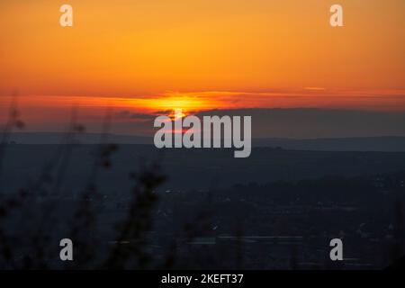 Halifax, Calvaire, West Yorkshire, Royaume-Uni. 12th novembre 2022. Météo Royaume-Uni. Un magnifique lever de soleil au-dessus des collines de Pennine du West Yorkshire, au-dessus de la ville de Halifax, à Calvaire, vue depuis le sommet de la colline près de Queensbury. Sur l'horizon se trouvent des silhouettes lointaines de moulins à vent. Crédit : Windmill Images/Alamy Live News Banque D'Images