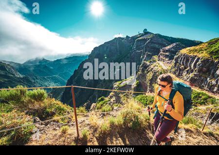 Description: Femme randonnée le long du sentier de randonnée pittoresque jusqu'à Pico Ruivo le matin. Pico do Arieiro, île de Madère, Portugal, Europe. Banque D'Images