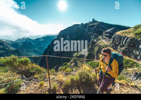 Description: Femme randonnée le long du sentier de randonnée pittoresque jusqu'à Pico Ruivo le matin. Pico do Arieiro, île de Madère, Portugal, Europe. Banque D'Images