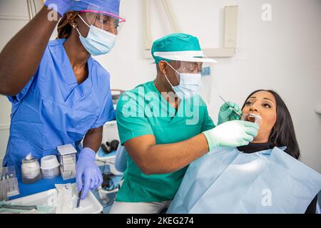 Un dentiste vérifie les dents d'un patient dans une clinique dentaire africaine Banque D'Images