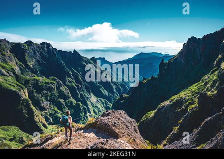 Description: Femme appréciant le paysage de montagne de point de vue très pittoresque le long de la randonnée à Pico Ruivo dans la matinée. Pico do Arieiro, île de Madère Banque D'Images