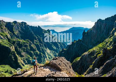 Description: Femme appréciant le paysage de montagne de point de vue très pittoresque le long de la randonnée à Pico Ruivo dans la matinée. Pico do Arieiro, île de Madère Banque D'Images