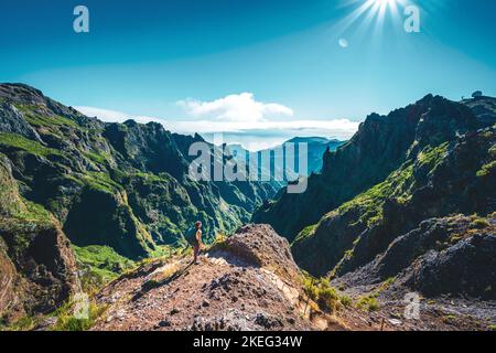 Description: Femme appréciant le paysage de montagne de point de vue très pittoresque le long de la randonnée à Pico Ruivo dans la matinée. Pico do Arieiro, île de Madère Banque D'Images